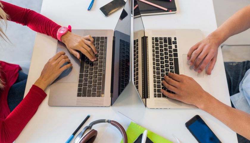 deux étudiants sur leur ordinateur face à face