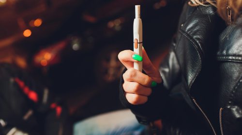 une femme tenant une cigarette électronique