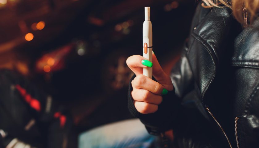 une femme tenant une cigarette électronique