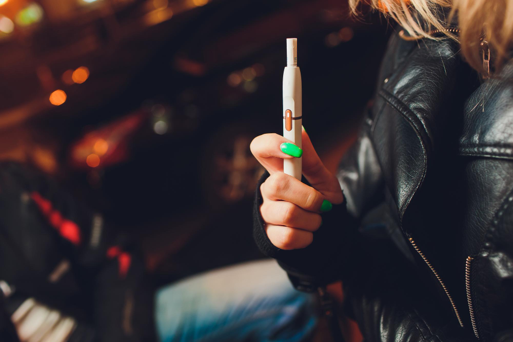 une femme tenant une cigarette électronique